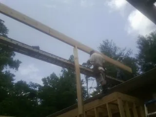 Carpenter setting a ridge beam over a new addition frame — Ice Dam Removal by Roofing Brothers in Bullhead City