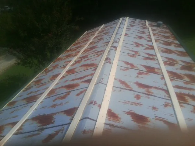 Rusted metal roof panels with new wood purlins before replacement — Storm Damage Roof Repair in Bullhead City by Roofing Brothers